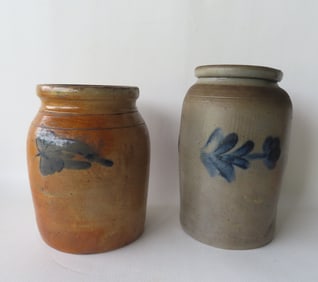 Two stoneware pantry jars decorated with cobalt blue flowers around the perimeters, the largest 10