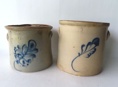 Two stoneware crocks, but decorated with a cobalt blue leaf, including 1 1/2 gallons and 2 gallons.