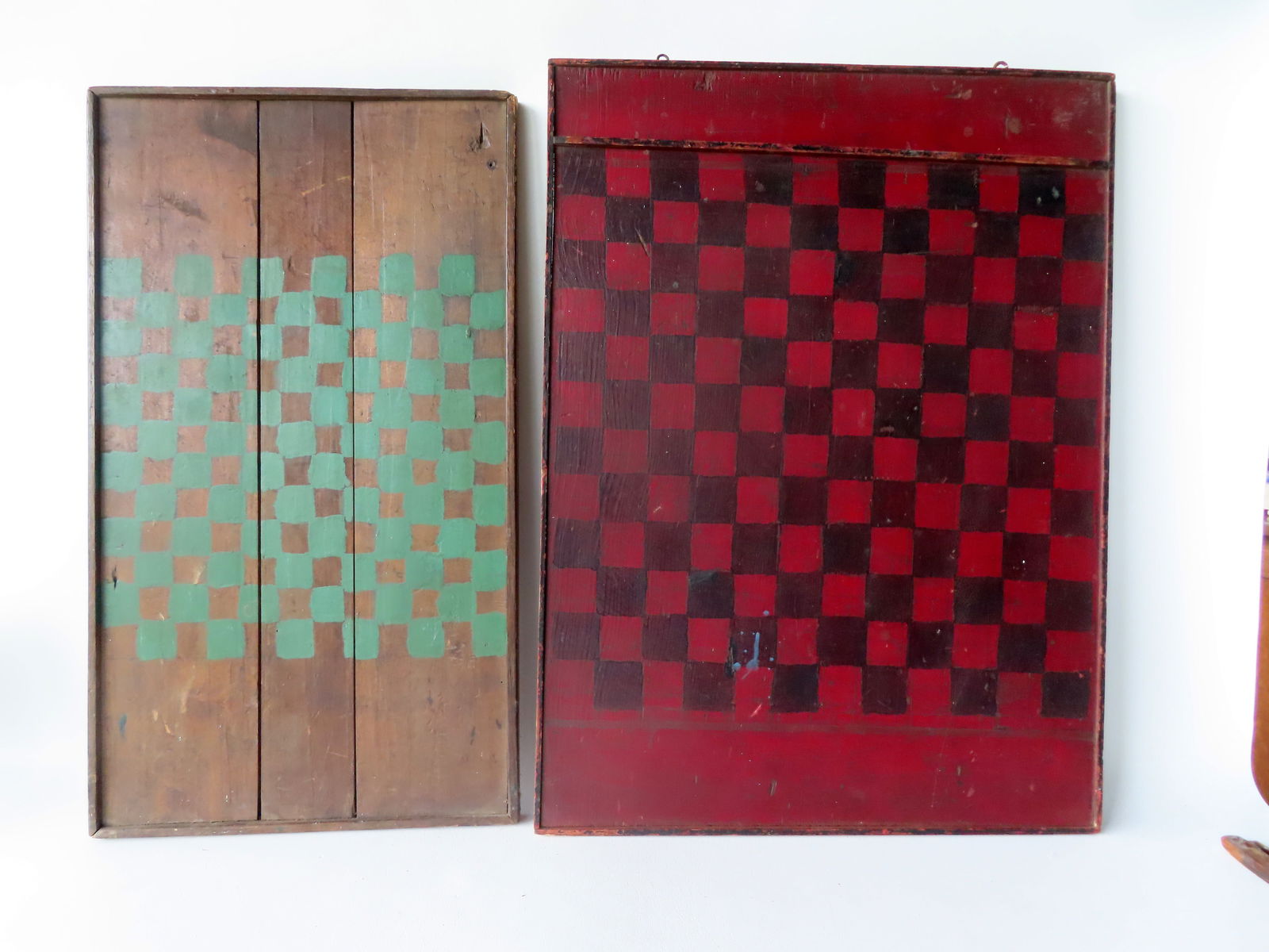 Two painted games in good condition, one with green squares on natural ground in good condition, the: Two painted games in good condition, one with green squares on natural ground in good condition, the other red squares on black ground and a Parcheesi game board on reverse - molding losses to the che