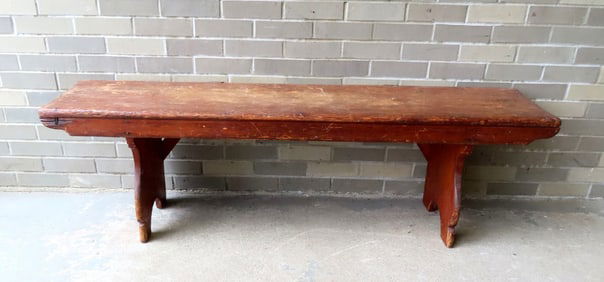 A primitive pine bench, in natural finish with side supports, half moon cutouts on legs, and square