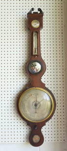 A English John Wilson mahogany banjo barometer, with 3 attached weather related dials and a small: A English John Wilson mahogany banjo barometer, with 3 attached weather related dials and a small convex bullseye mirror, signed within a lower medallion "John Wilson / Gazeley Warranted". Some mahoga