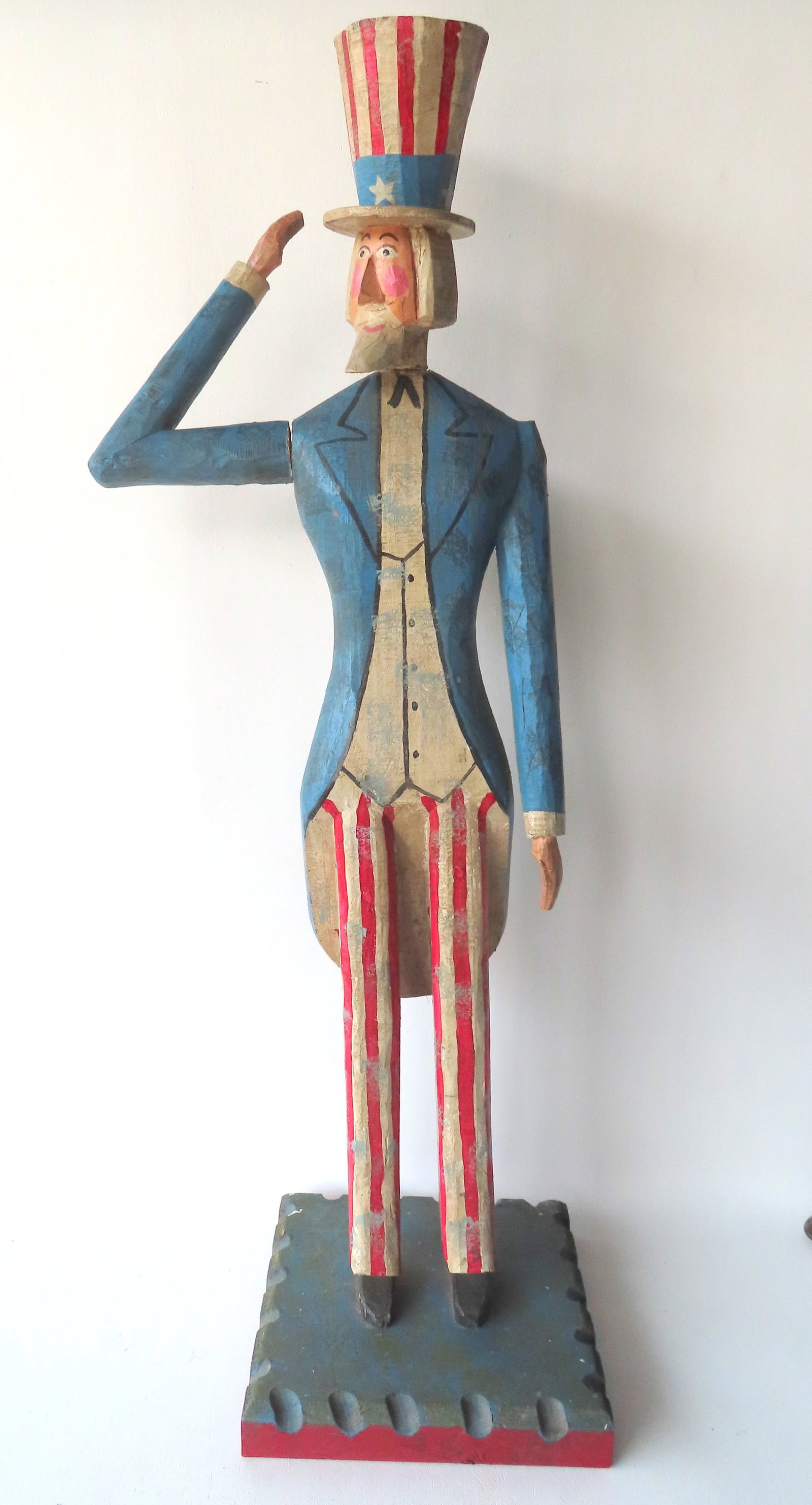 A folk art carved wooden sculpture of Uncle Sam in original paint, circa late 20th century. Good: A folk art carved wooden sculpture of Uncle Sam in original paint, circa late 20th century. Good condition. Measures 34"H x 12"W x 9 1/2" square at base.