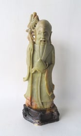 A carved stone figure of oriental gentleman with dragon on shoulder, mounted on alabaster base.