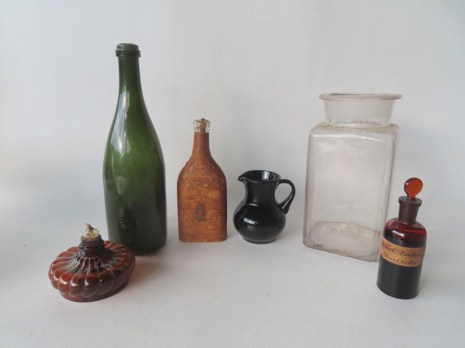 Grouping of vintage bottles and other glass. The druggist jar in colorless glass is hand blown but: Grouping of vintage bottles and other glass. The druggist jar in colorless glass is hand blown but no lid; an olive water bowl with pushed up bottom - this is the largest measuring 12"H; flask shaped