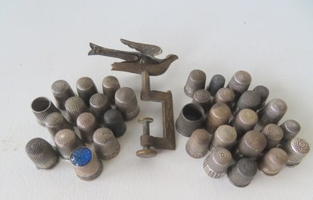 Grouping of 34 vintage silver thimbles and a Victorian brass sewing bird. All appear to be late 19th