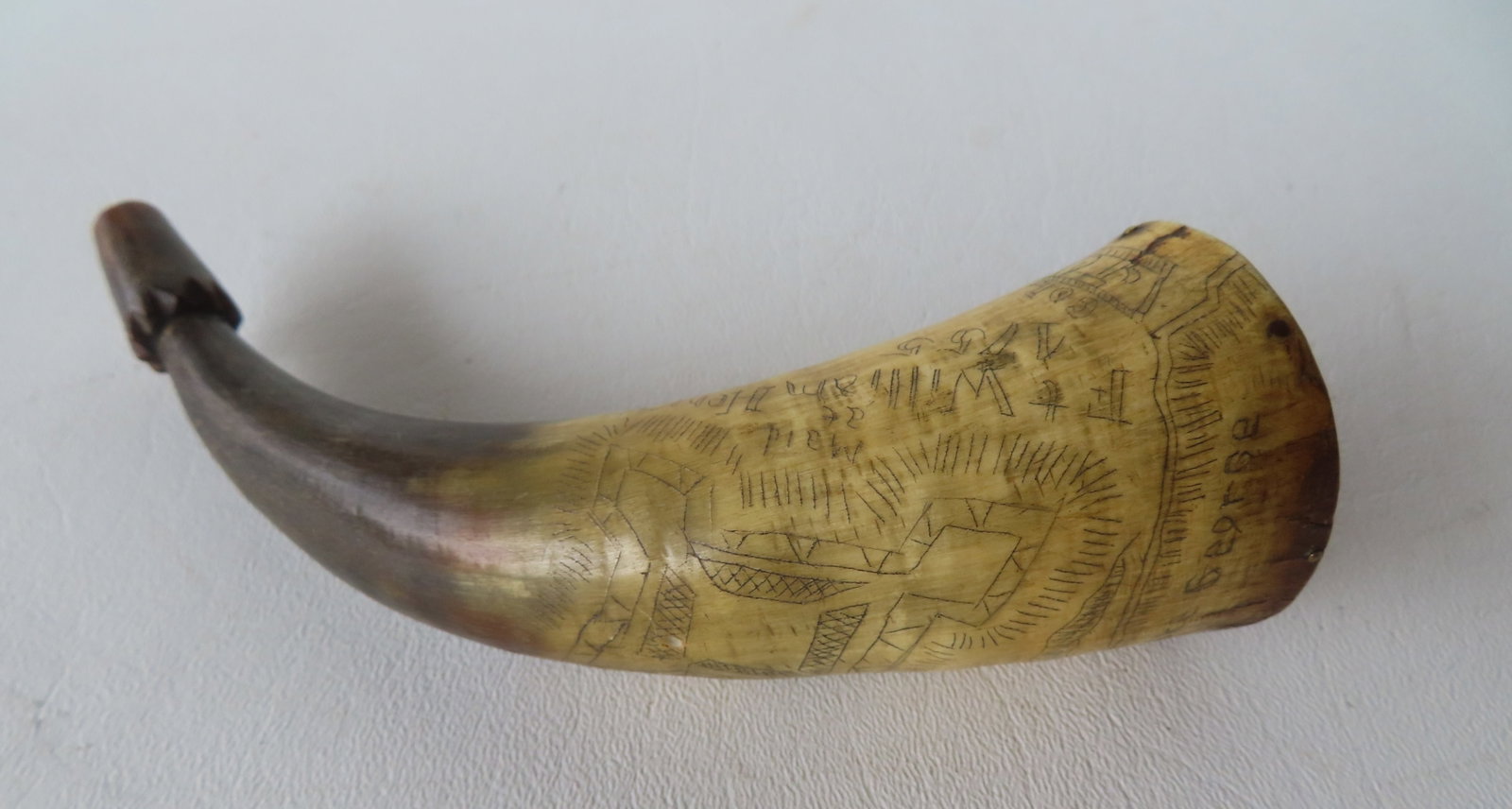 A scrimshaw powder horn engraved "Col. Jonathan Bagley / Lake George" and "Fort William Henry 1755": A scrimshaw powder horn engraved "Col. Jonathan Bagley / Lake George" and "Fort William Henry 1755" with image of fort and a frontiersman and British soldier. The plug is missing and the wooden cap on