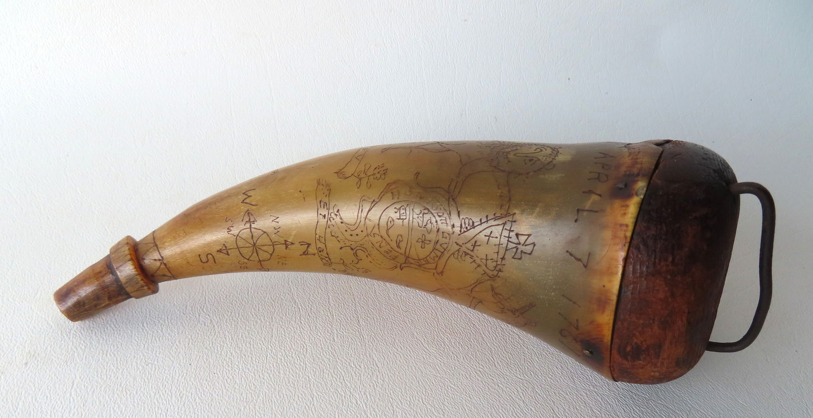 A folk art powder horn with extensive scrimshaw work including signed "J. C. Watson's Horn / April: A folk art powder horn with extensive scrimshaw work including signed "J. C. Watson's Horn / April 7 1761" - also decorated with a map of the Lake George area with forts and a crest flanked by lion an