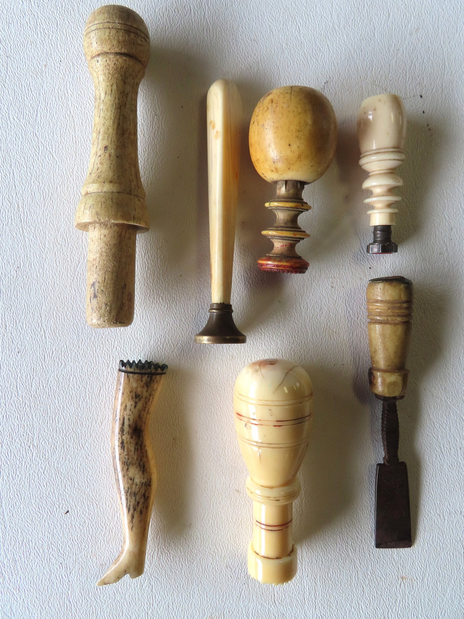 Grouping of 7 marine collectibles including: 2 wax seals, pipe tamper in the form of leg, etc.: Grouping of 7 marine collectibles including: 2 whalebone wax seals,3 early pipe tampers including an ivory pipe tamper in the form of a lady's leg, mid to late 19th century; a small bone handled chise