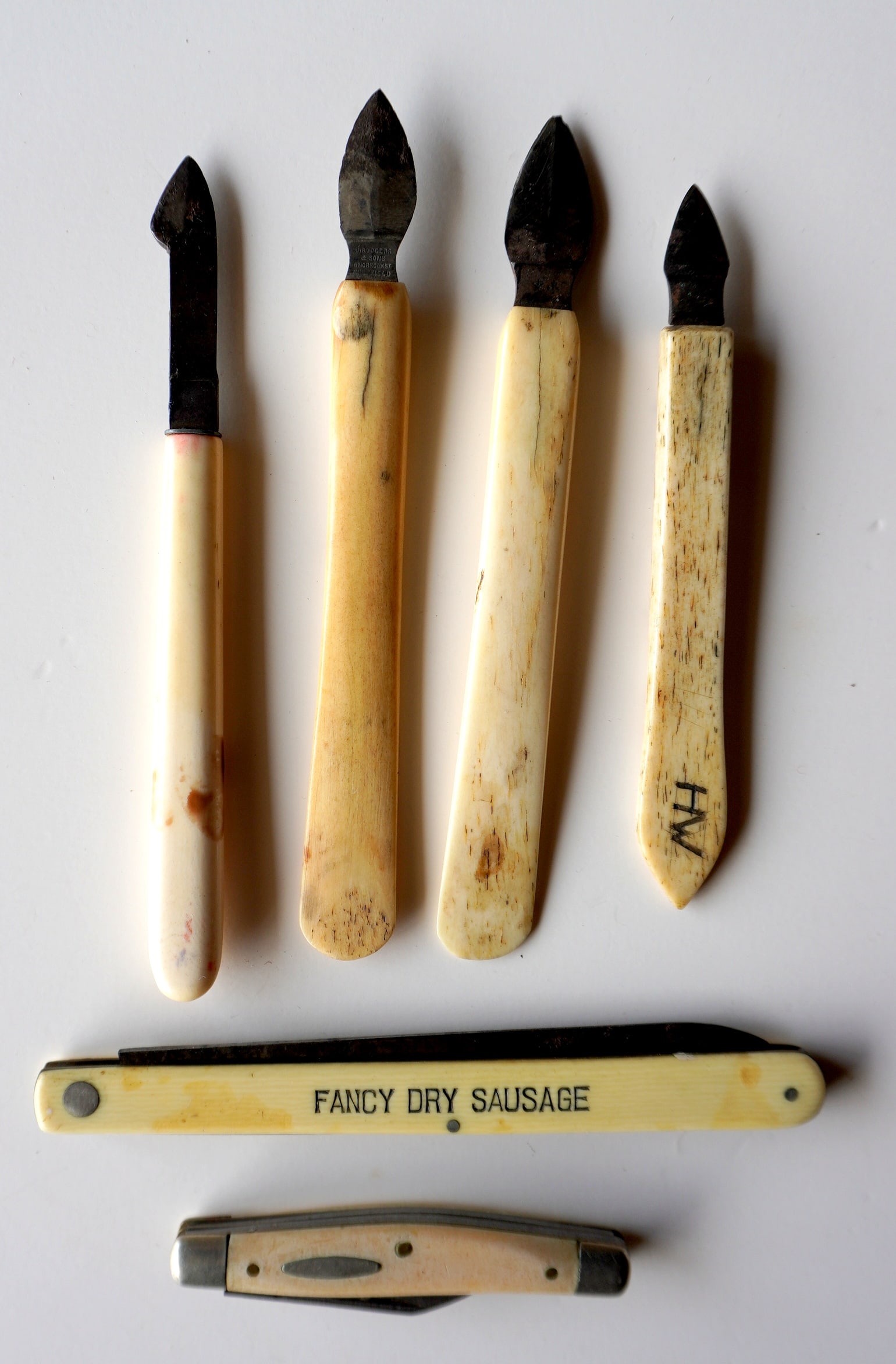 A grouping of vintage cutting instruments, late 19th century, including: 4 surgical or bloodletting: A grouping of vintage cutting instruments, late 19th century, including: 4 surgical or bloodletting tools circa 1850-70 with bone handles; a “Cudahy Packing” pocket knife with faux ivory handl