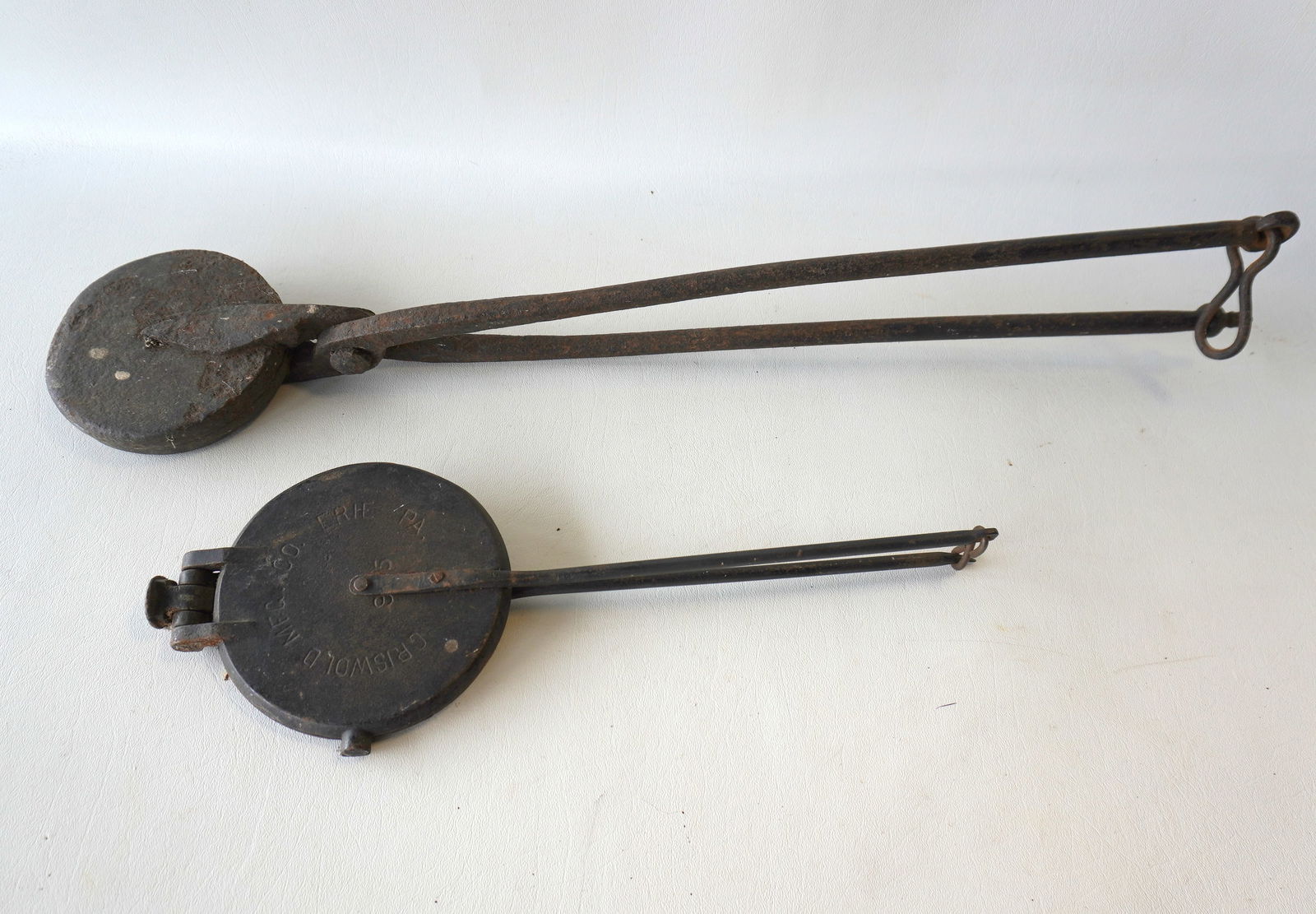 Two early hearth waffle irons, Pennsylvania. The first, hand forged, with tulip design with leaves -: Two early hearth waffle irons, Pennsylvania. The first, hand forged, with tulip design with leaves - late 18th century, probably Pennsylvania - 27"L; the second, a Griswold waffle iron, patent June 29