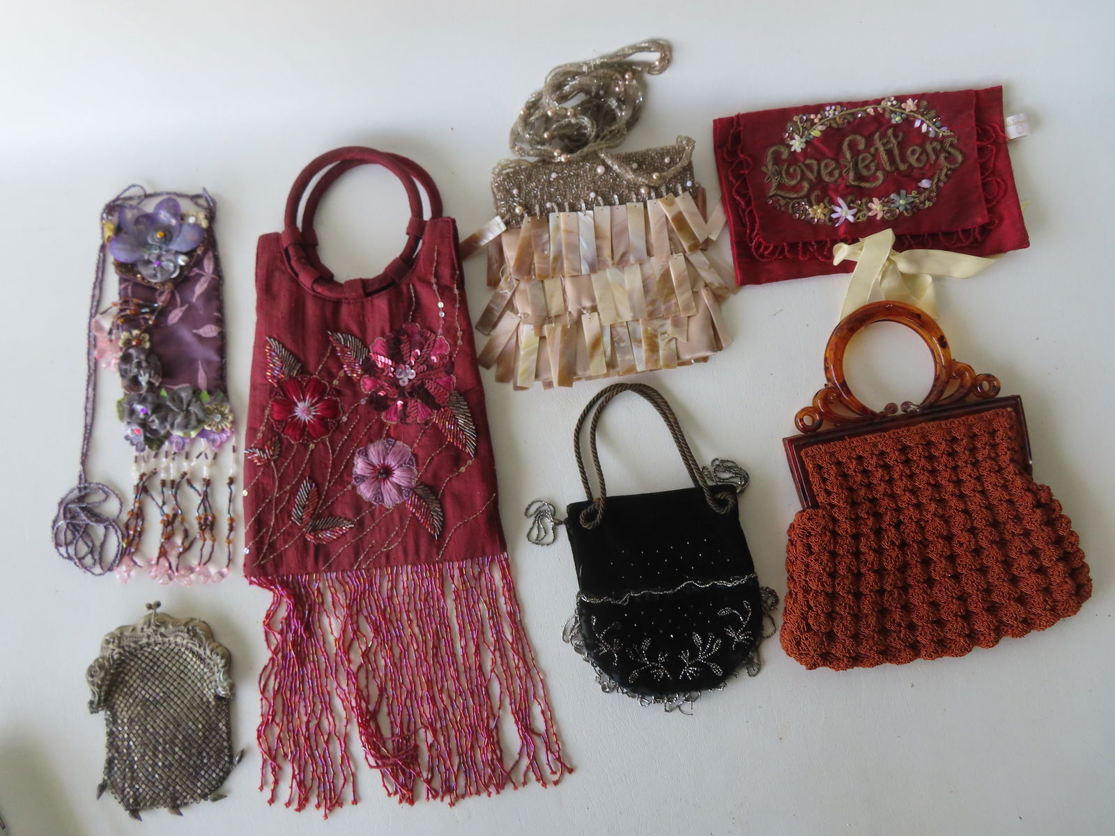 Grouping of 7 fancy ladies bags including evening bag, "Letter" bag, etc. Most in very good: Grouping of 7 fancy ladies bags including evening bag, "Letter" bag, etc. Most in very good condition and circa 1930 to late 20th century. The largest, a modern embroidered bag labeled "Made in India"