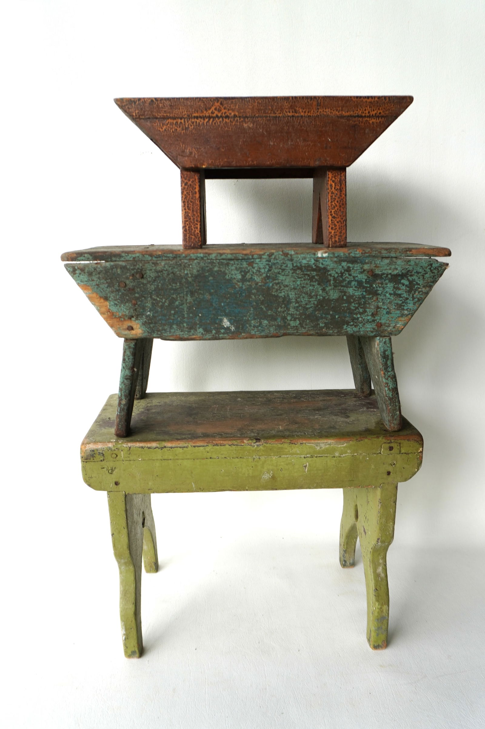 Three primitive cricket stools in old paint, including one in old blue-green paint (worn), late 19th: Three primitive cricket stools in old paint, including one in old blue-green paint (worn), late 19th to early 20th century. Typical use wear and in good condition. The largest measures 15"W x 7 1/2"D
