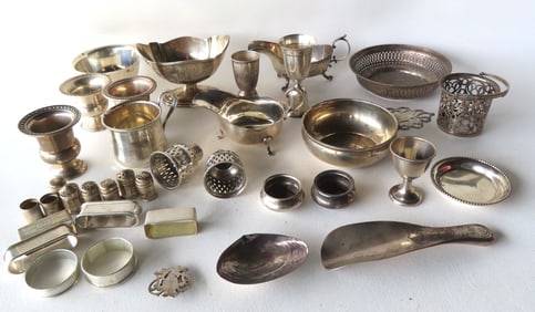 A large grouping of sterling silver including napkin rings, child's cup, gravy boat, shoe horn, salt