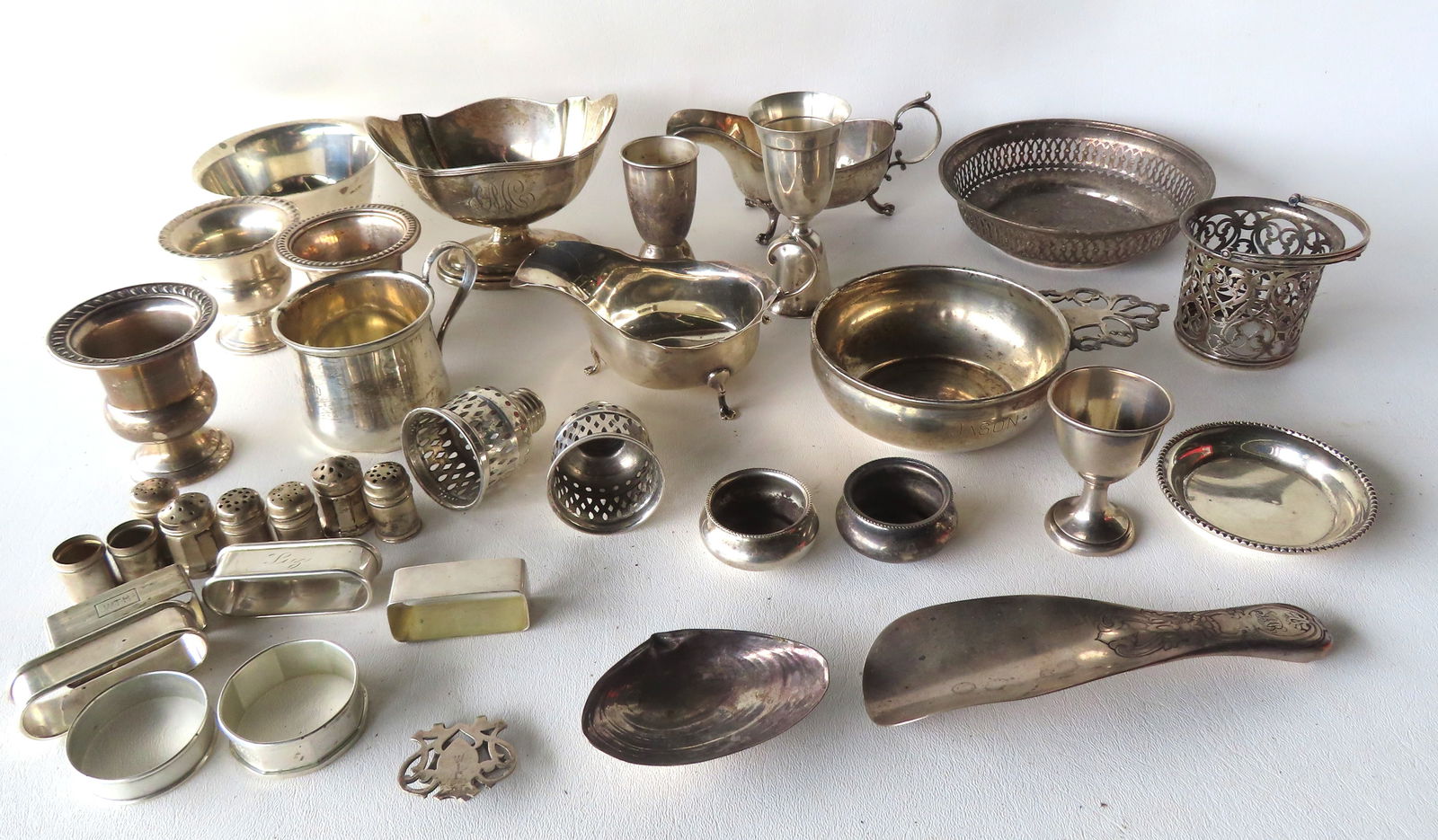 A large grouping of sterling silver including napkin rings, child's cup, gravy boat, shoe horn, salt: A large grouping of sterling silver including napkin rings, child's cup, gravy boat, shoe horn, salt cellar, etc. Total weight 44.7 troy ozs of pure silver.
