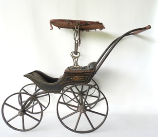 A Victorian stenciled doll carriage with canopy and wooden wheels, late 19th century.