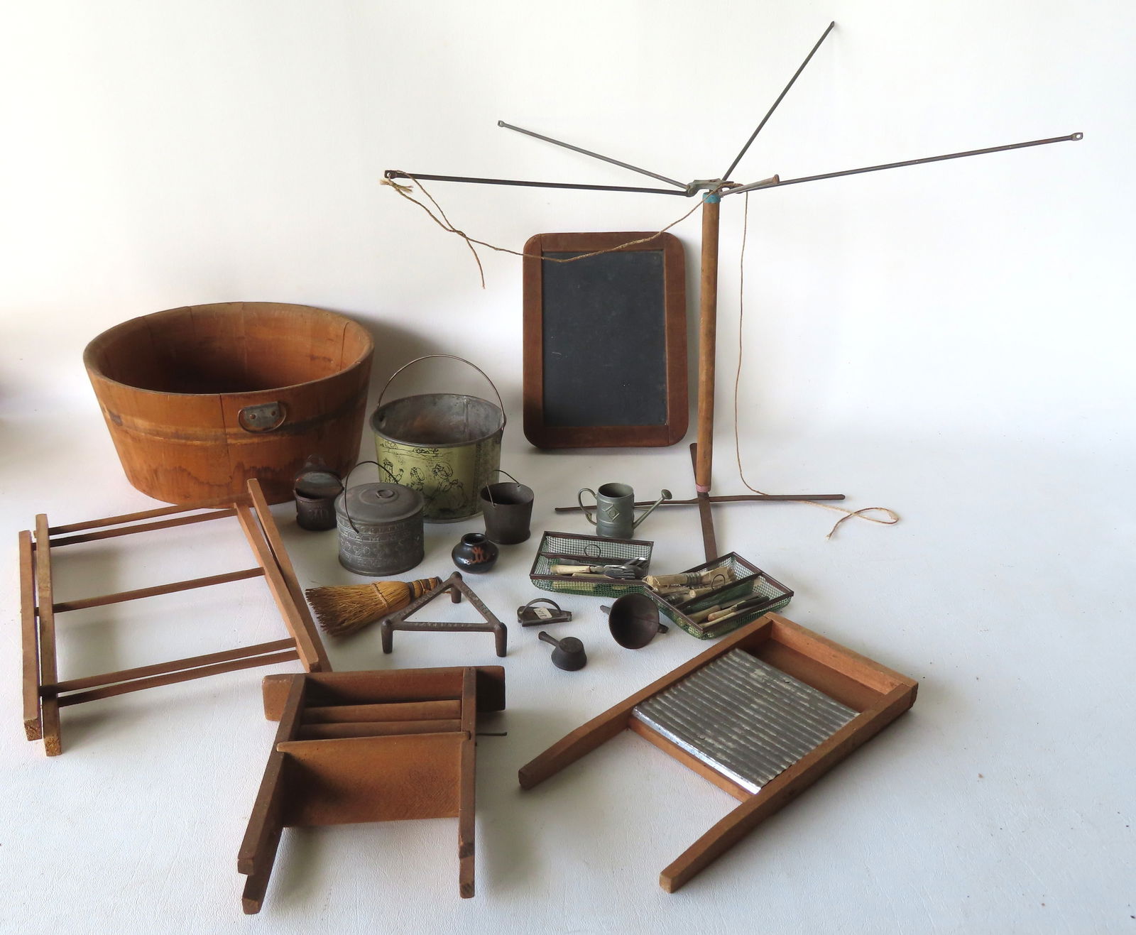 Grouping of doll related vintage toys, most washing related, including drying racks, flatware set,: Grouping of doll related vintage toys, most washing related, including drying racks, flatware set, clothespins, washing buckets, whisk broom, cooking pots including one in tin decorated with the alpha