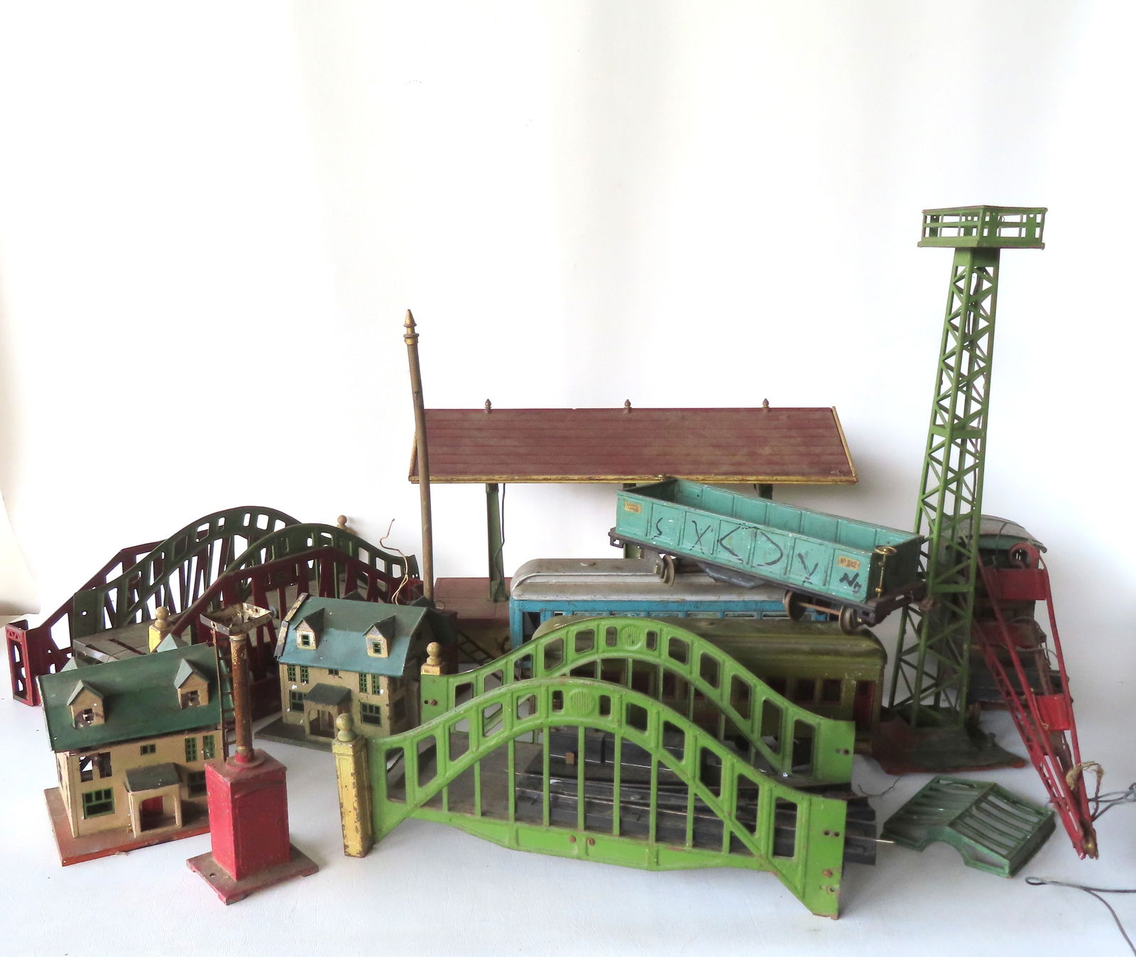Grouping of Lionel pressed steel and tin train accessories and a few cars, most pre-war and: Grouping of Lionel pressed steel and tin train accessories and a few cars, most pre-war and O-guage,including: Two No. 189 Villa - one with paint flaking and losses and missing chimney - the other wit