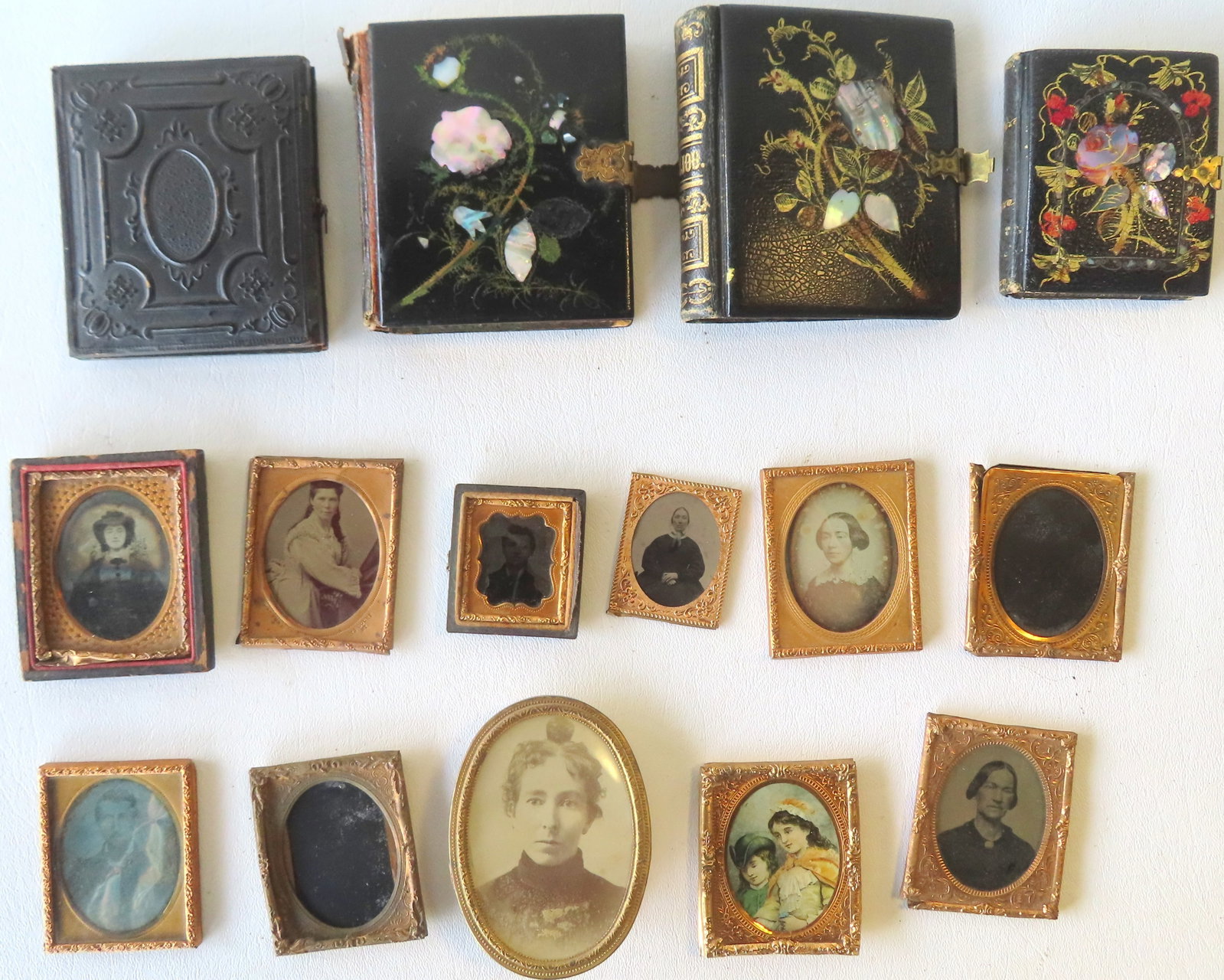 Grouping of mostly cased photographs including: Daguerreotype of lady in paper mache case with some: Grouping of mostly cased photographs including: Daguerreotype of lady in paper mache case with some losses - this is the largest measuring 3 3/4" x 3 1/2"; a good paper mache photo case decorated with