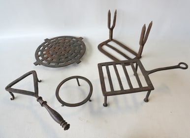 Grouping of 5 hand forged iron trivets, 18th/19th century, most in good condition. The largest, a ro