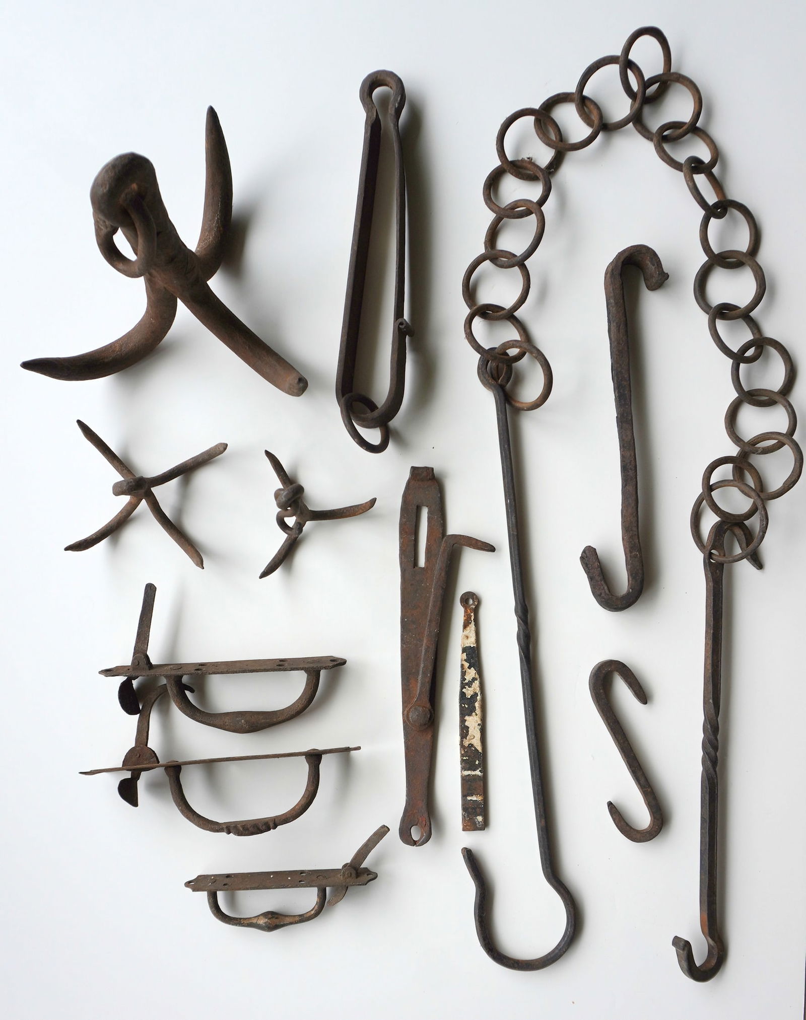 Grouping of mostly hand forged iron collectibles including grappling irons, Norfolk latches, firepla: Grouping of mostly hand forged iron collectibles including grappling irons, Norfolk latches, fireplace chain trammel - this is the largest measuring 6' in hanging position, etc., 18th/19th century - m