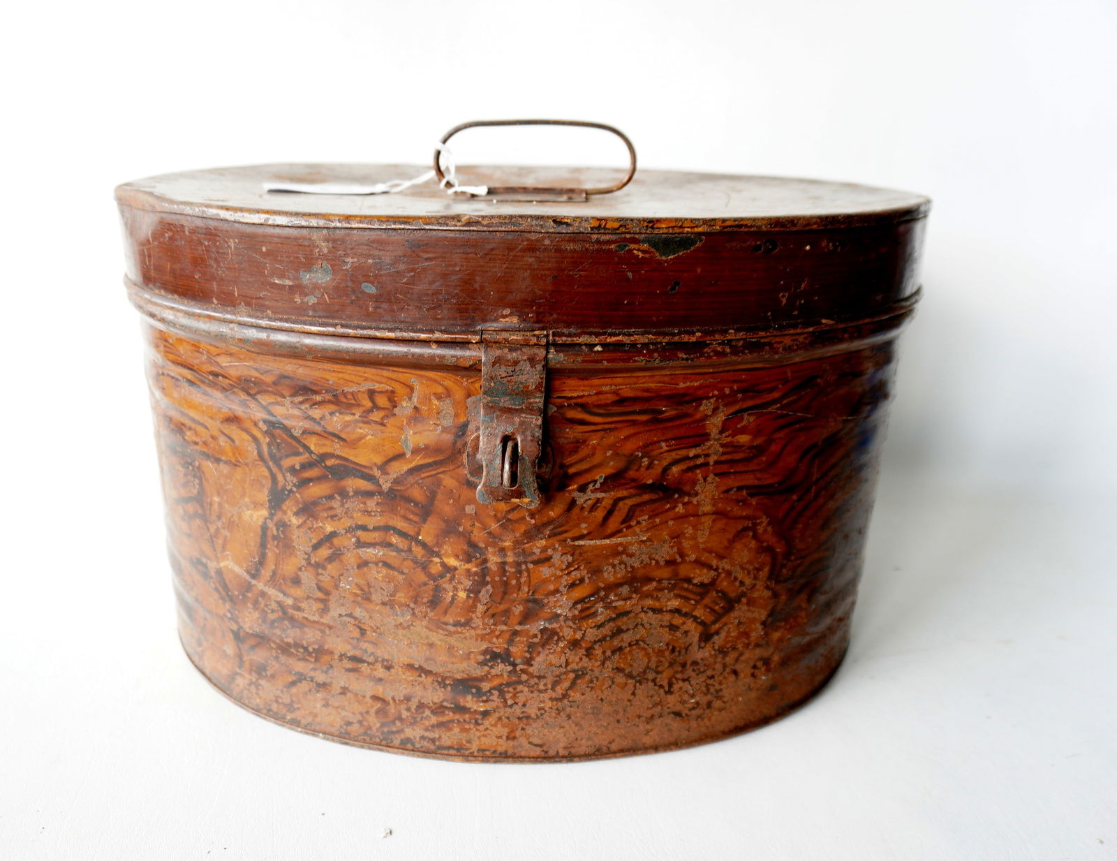 A grain painted tin hat box, 19th century, worn paint, else good condition.: A grain painted tin hat box, 19th century, worn paint, else good condition. Measures 17 3/4"W x 11"H. Provenance: From the Marni Bakst and William Sadler collection of antiques, Verbank NY.