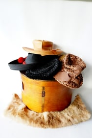 An early wooden hat box filled with lady's bonnets, 19th century.