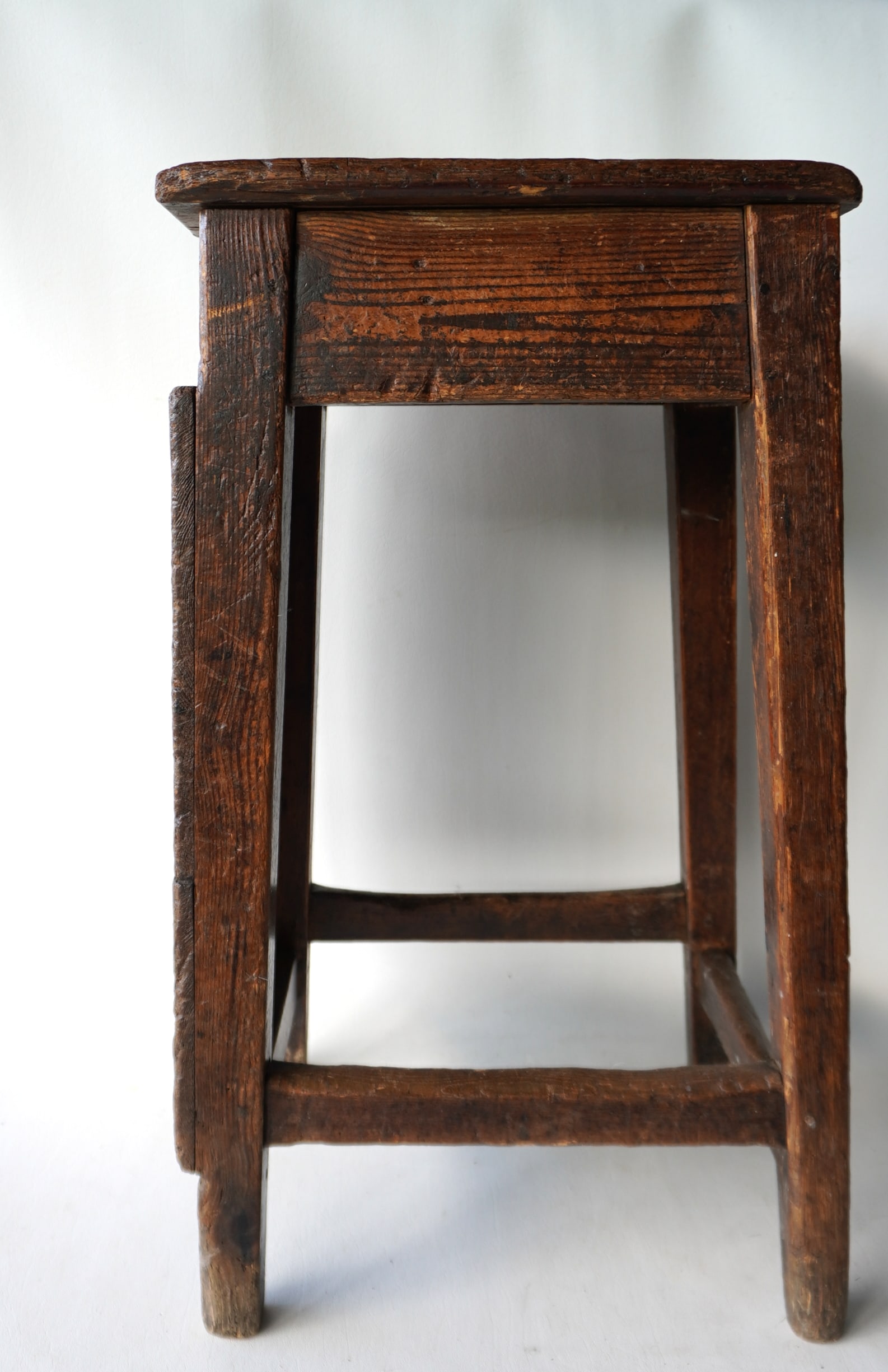 A very primitive 18th century tradesman stool with worn cross stretchers: A very primitive 18th century tradesman stool with worn cross stretchers, probably for a farrier - extensive use wear as would be expected and overall good structural condition. Measures 14 3/4"W x 11