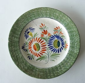 An early Quimper tin glazed hand painted wall display plate in spatterware form.