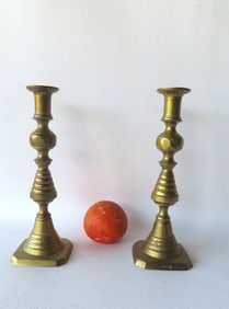 A pair of brass pushup candlesticks, beehive pattern, marked "England".