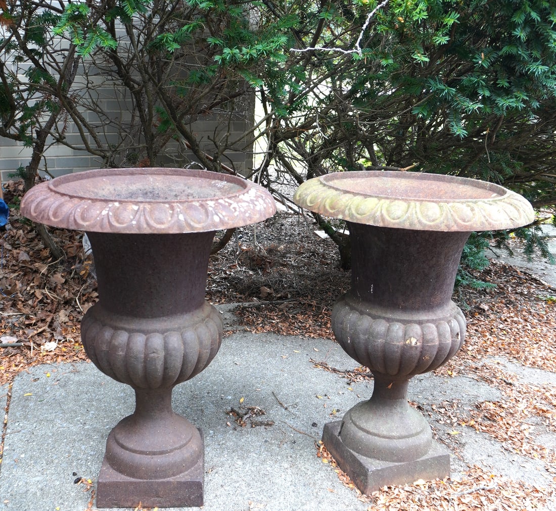Two cast iron garden urns with flared rims, 1 piece construction. Probably early to mid 20th: Two cast iron garden urns with flared rims, 1 piece construction. Probably early to mid 20th century, both in very good condition. Each measures 22 1/4" diameter x 30"H. Provenance: Private collector,