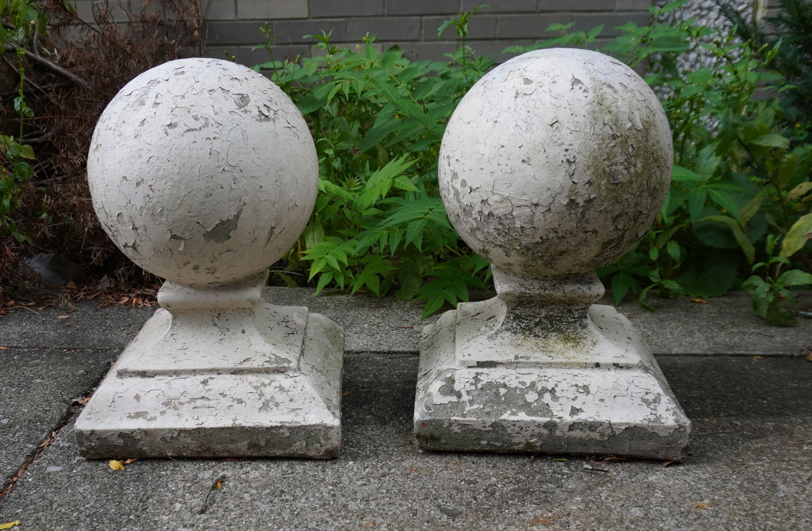 Two large concrete orbs on stepped bases (post finials), early 20th century. Both in very good: Two large concrete orbs on stepped bases (post finials), early 20th century. Both in very good condition with layers of old white paint. Each measures 16 1/2"H x 11 3/4" square at base. Provenance: Pr