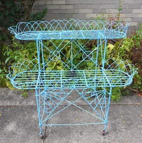 A Victorian wire 2 tier planter on original wheels, 19th century, in old blue paint. Measures 33"W x