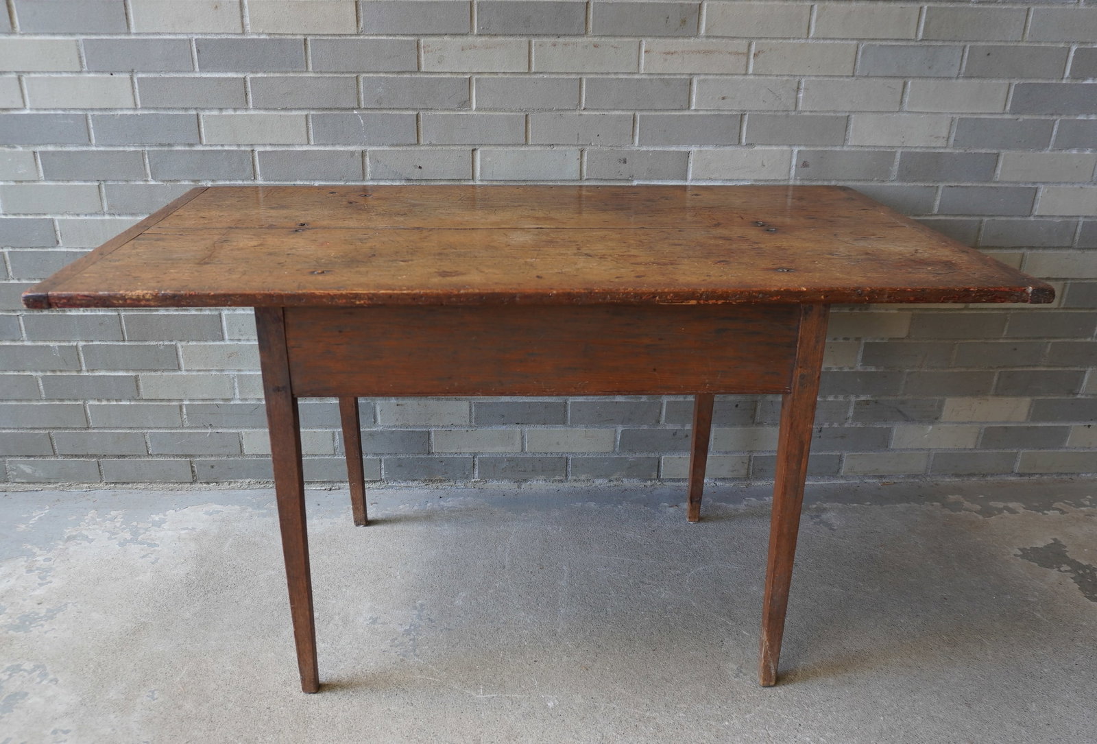 An American tapered leg tavern table having its original scrubbed pine top with breadboard ends,: An American tapered leg tavern table having its original scrubbed pine top with breadboard ends, New England circa 1790-1800. Never had a drawer. Typical use wear to top with expansion crack, otherwis