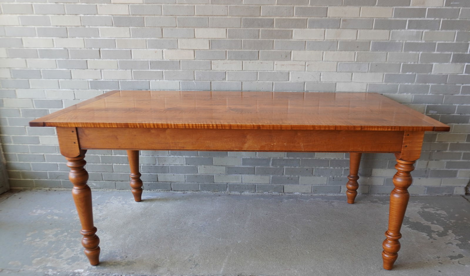 A Leonard's custom made tiger maple farm table with turned legs and breadboard ends. Signed in 2: A Leonard's custom made tiger maple farm table with turned legs and breadboard ends. Signed in 2 places on reverse side of apron "Leonard's Seekonk MA". Minor use wear, and overall very good condition