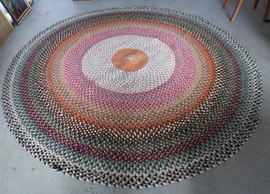 A circular room size braided rug. Small section on border slightly loose, hardly noticeable,