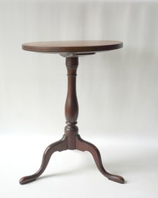 A mahogany Queen Ann candle stand with line inlay around the perimeter of round top and 2 bands of