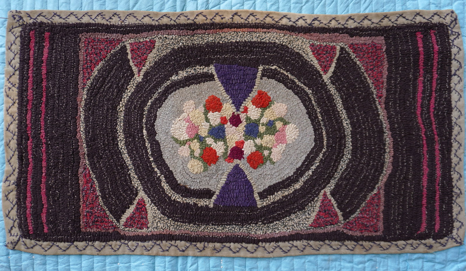 A good early folk art free style hooked rug on burlap, with crocheted homespun border having a: A good early folk art free style hooked rug on burlap, with crocheted homespun border having a central medallion of a bouquet of flowers, probably 19th century in very good condition. Measures 39 1/2"
