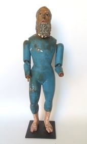 A carved wooden Santos figure of a jointed bearded man with glass eyes in original blue paint,