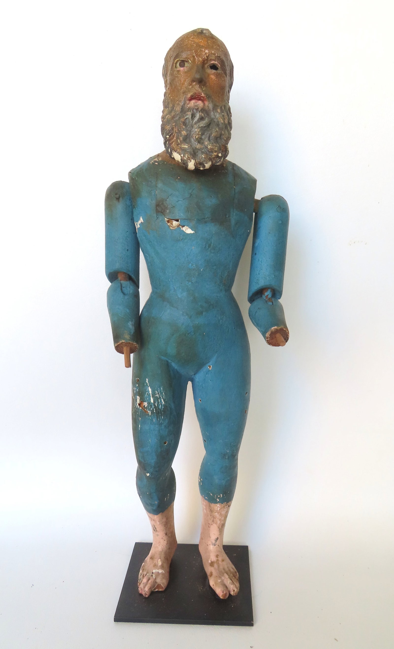 A carved wooden Santos figure of a jointed bearded man with glass eyes in original blue paint,: A carved wooden Santos figure of a jointed bearded man with glass eyes in original blue paint, Italian or Spanish colonial, late 18th to early 19th century. Missing hands, missing one glass eye, else 