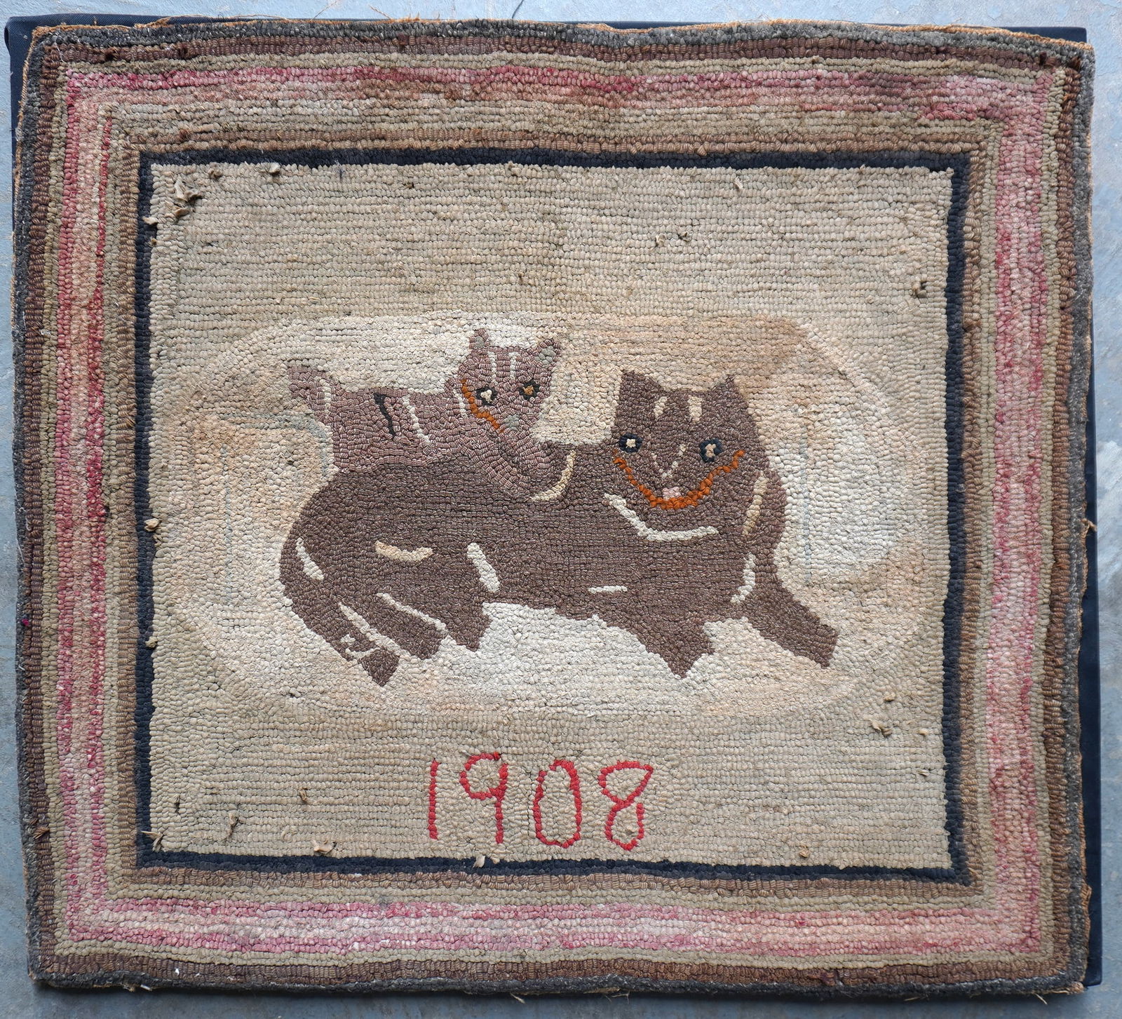A folk art mounted hooked rug with a central image of a kitten resting on mother cat's back who is: A folk art mounted hooked rug with a central image of a kitten resting on mother cat's back who is reclining on rug and dated 1908. Several small age related stains hardly noticeable, some pulls in wo