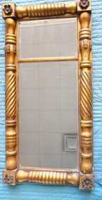 A large Sheraton gilt gesso double panel wall mirror with turned and twisted columns flanking mirror
