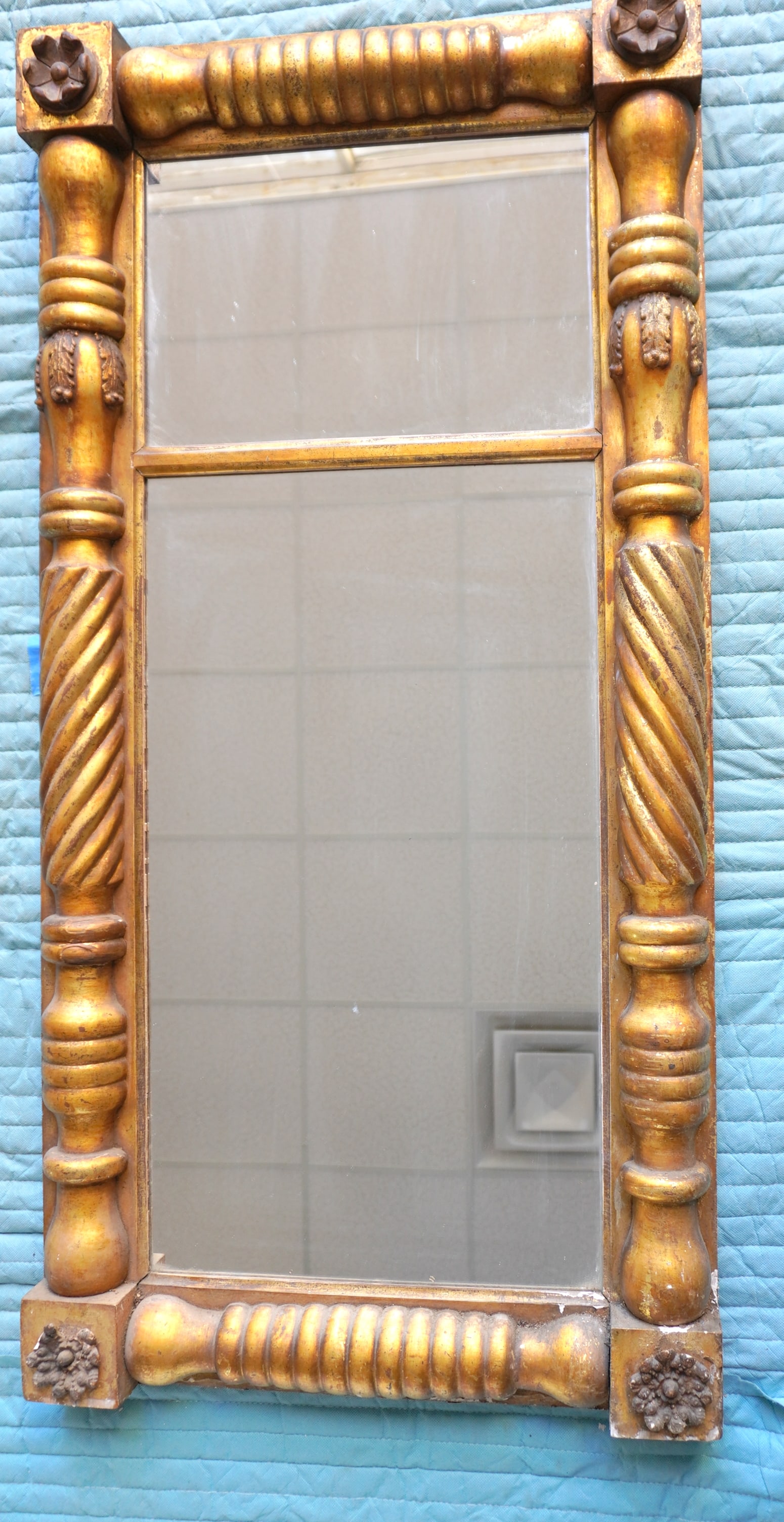 A large Sheraton gilt gesso double panel wall mirror with turned and twisted columns flanking mirror: A large Sheraton gilt gesso double panel wall mirror with turned and twisted columns flanking mirror with rosettes in each corner, circa 1830. The rosette in bottom left corner with small losses, typi