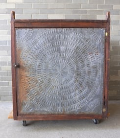 A primitive hanging pierced tin pie safe having large pierced tin panels on all 4 sides - each panel