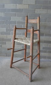 A primitive child's high chair with traces of original blue paint, turned and splayed legs with