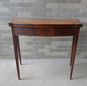 An inlaid mahogany Hepplewhite flip top game table with swing leg and shaped top - various inlays on