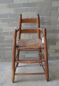 An early child's high chair with turned stiles and arms and with button finials and turned splayed