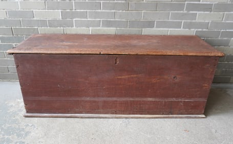 A primitive late 17th century blanket box in original red stain, with molded edge to lid and with