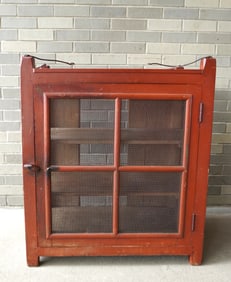 A primitive wall hanging screened pie safe in original red paint, with iron ceiling hangers that are