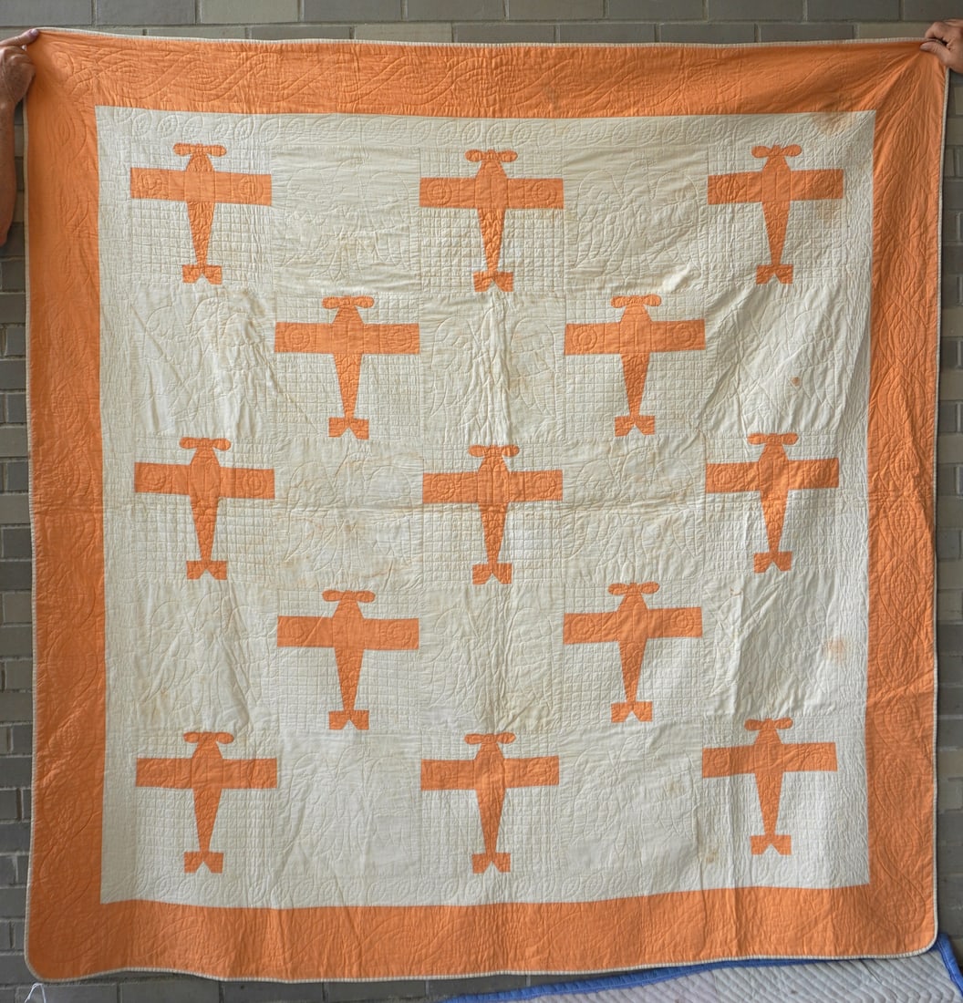 A folk art Charles Lindbergh airplane quilt decorated with orange images of the Spirit of St. Louis,: A folk art Charles Lindbergh airplane quilt decorated with orange images of the Spirit of St. Louis, probably to commemorate his non-stop voyage across the Atlantic Ocean in 1927. The planes are alter