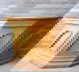 A mustard colored grain painted 5 sided podium having a deep molded base and molded edge to top -